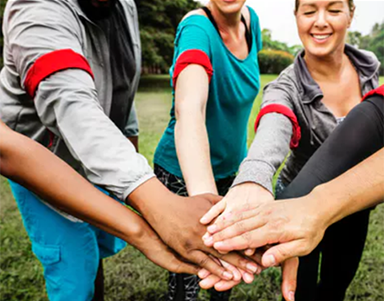 People in a group putting hands together