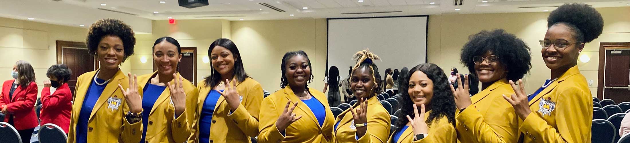 Sigma Gamma Rho members in yellow and blue.